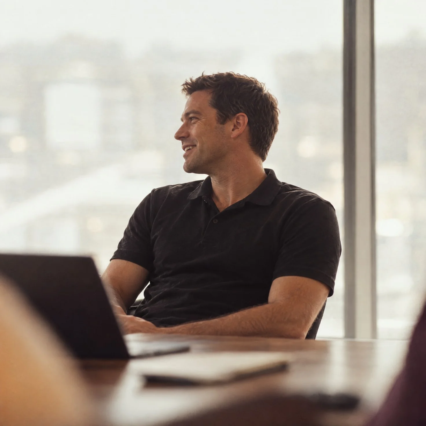 Two people at a desk looking over a dashboard on a laptop.
